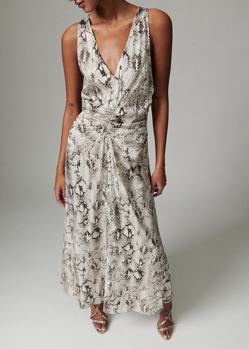 Woman wearing a snake print dress with a gray background