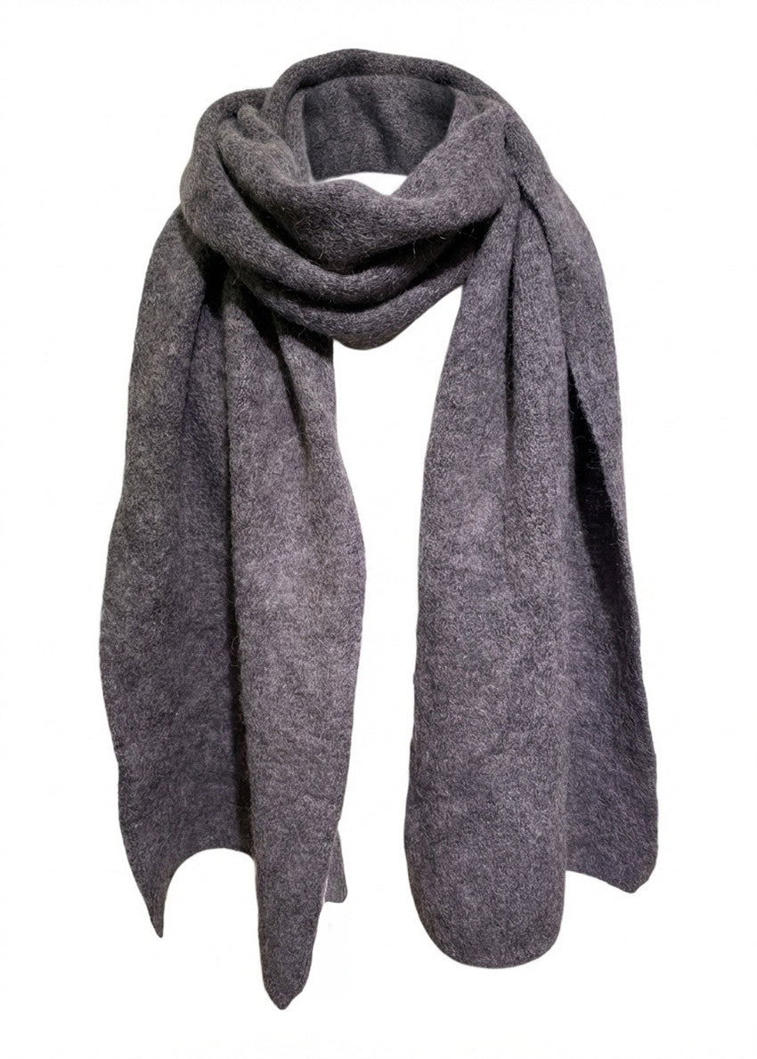 Person wearing a large gray scarf against a white background