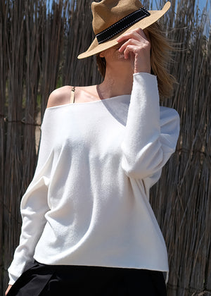 Woman hiding her face with a hat wear a white sweater