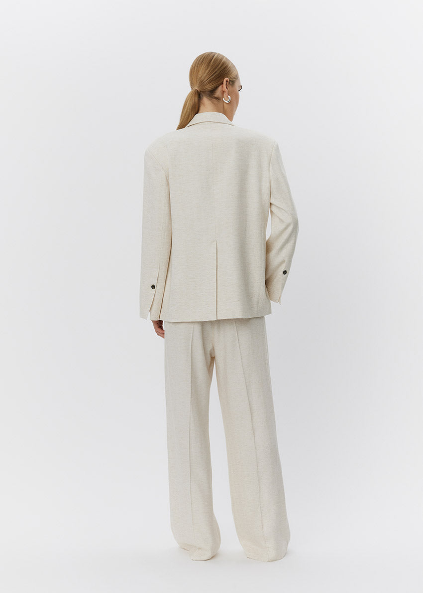 Person wearing a beige suit on a white background