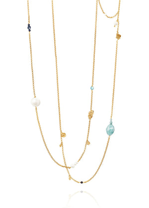 Layered gold necklace with various beads on a white background