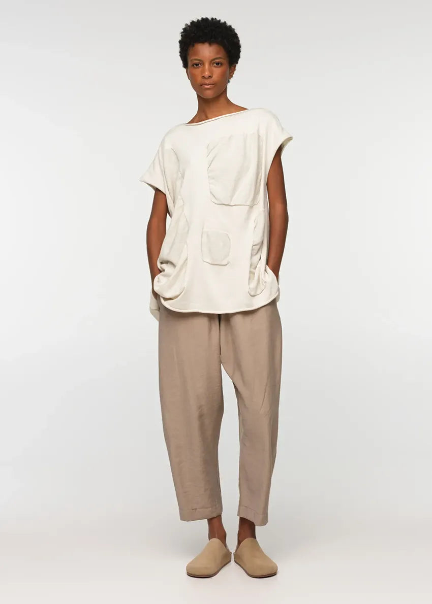 Unisex, mid-length tan trousers, made from soft, non-stretch rayon fabric, in a relaxed, organic cut, featuring a wide elastic waistband, a dropped crotch, and front pockets