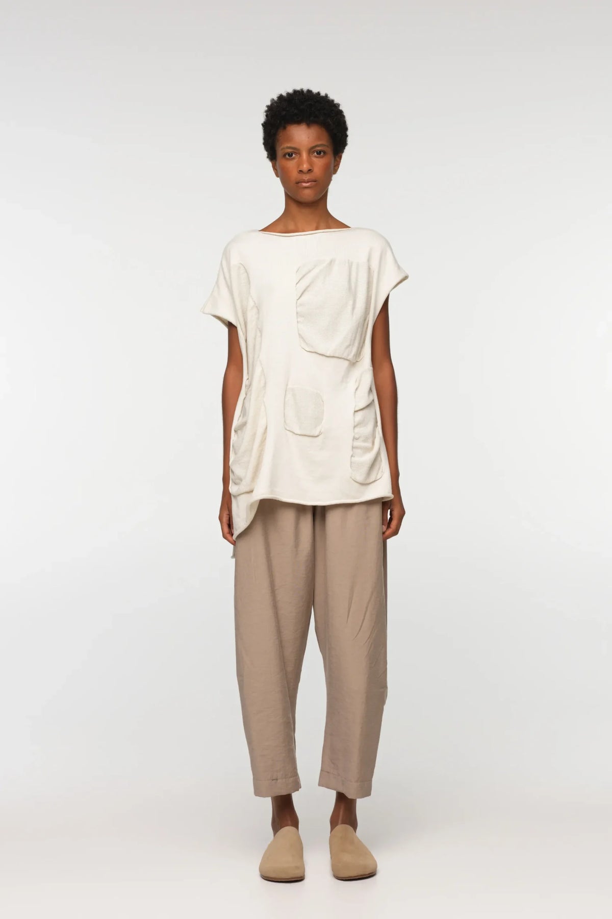 Unisex, mid-length tan trousers, made from soft, non-stretch rayon fabric, in a relaxed, organic cut, featuring a wide elastic waistband, a dropped crotch, and front pockets