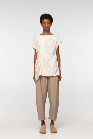 Unisex, mid-length tan trousers, made from soft, non-stretch rayon fabric, in a relaxed, organic cut, featuring a wide elastic waistband, a dropped crotch, and front pockets