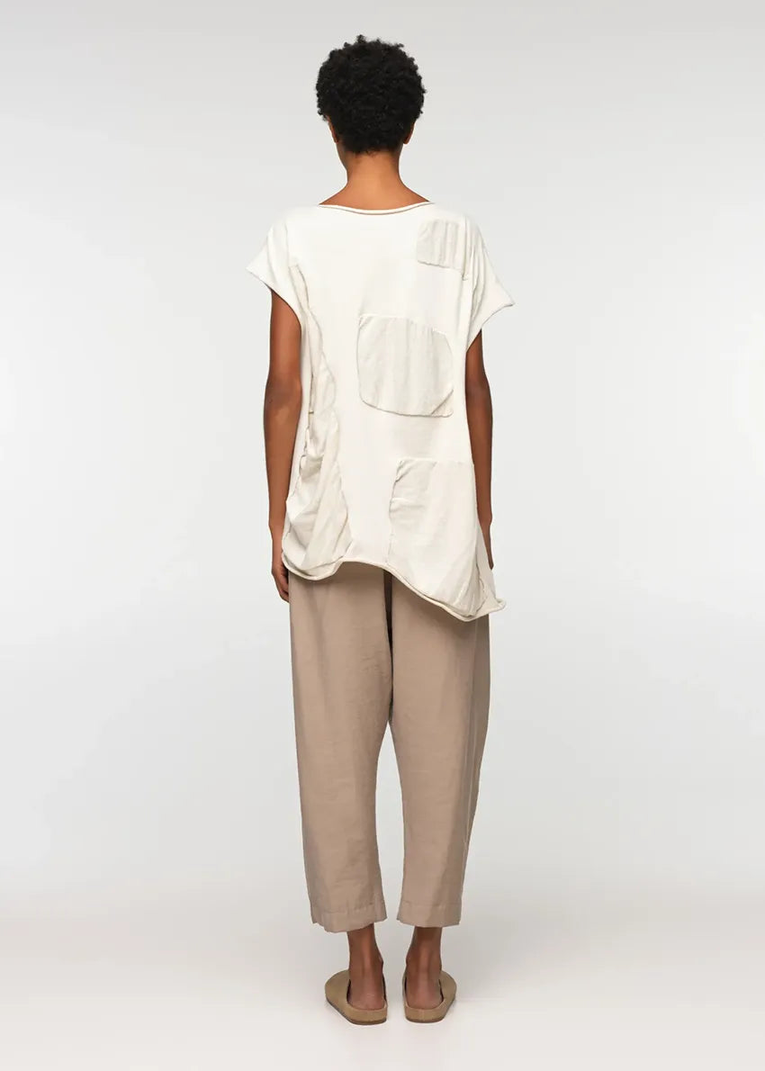 Unisex, mid-length tan trousers, made from soft, non-stretch rayon fabric, in a relaxed, organic cut, featuring a wide elastic waistband, a dropped crotch, and front pockets