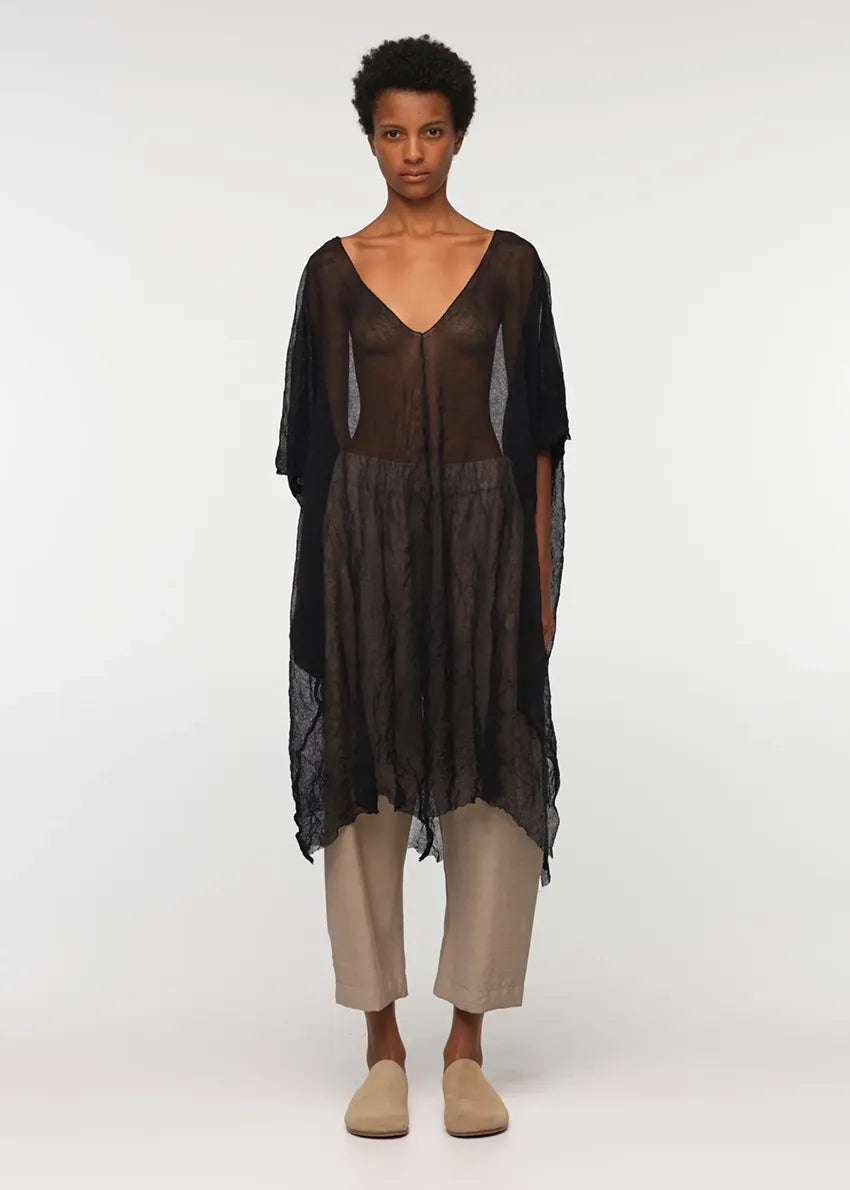 Unisex, mid-length tan trousers, made from soft, non-stretch rayon fabric, in a relaxed, organic cut, featuring a wide elastic waistband, a dropped crotch, and front pockets