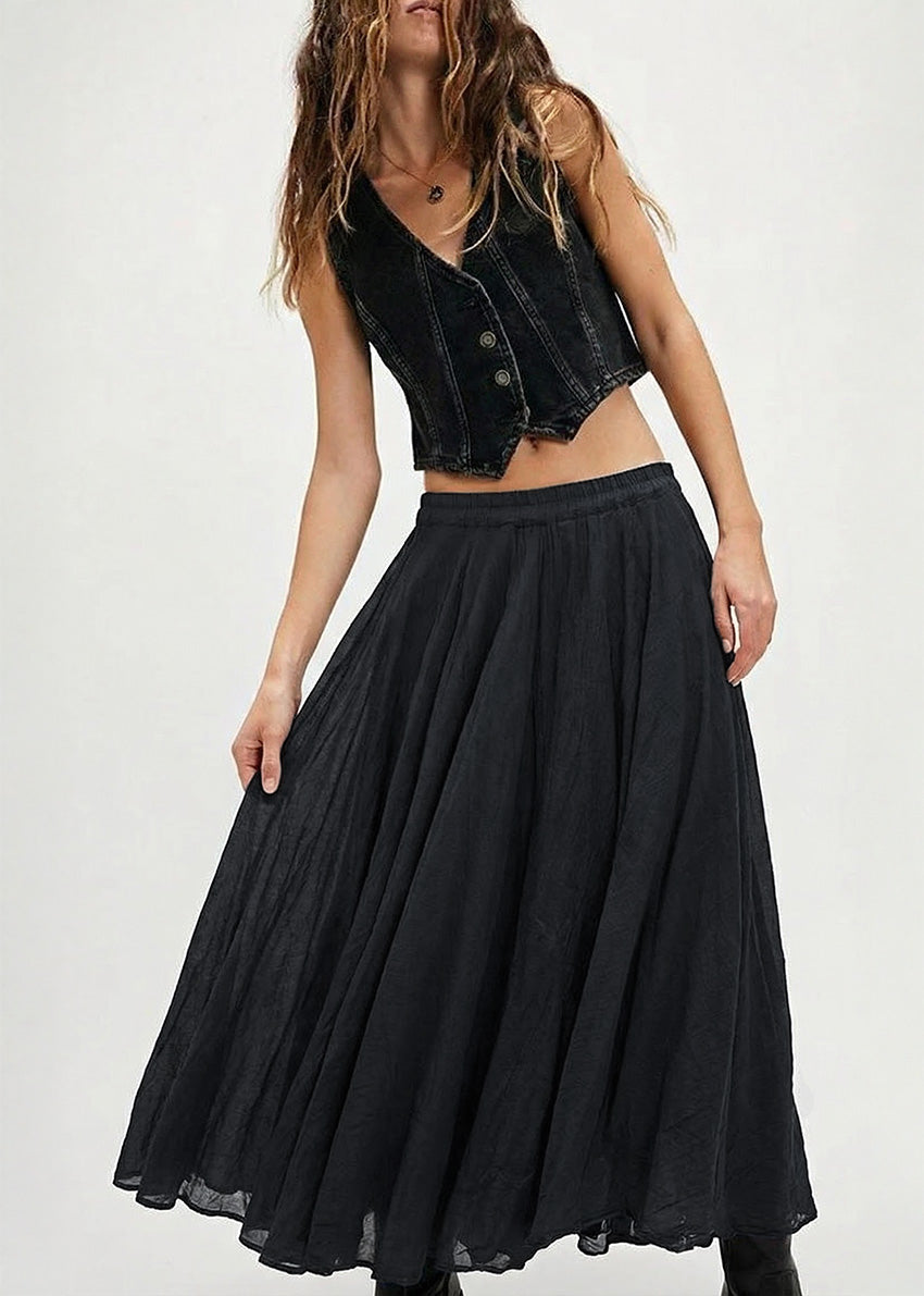Woman wearing a black denim vest over a black skirt on a white background