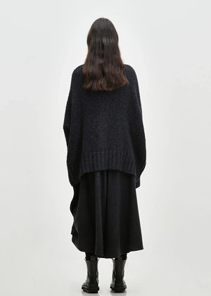 Asymmetrical skirt with a decorative diagonal ruffle made of soft blended wool flannel. ONDA features an elastic waistband and a zipper closure on the back side.