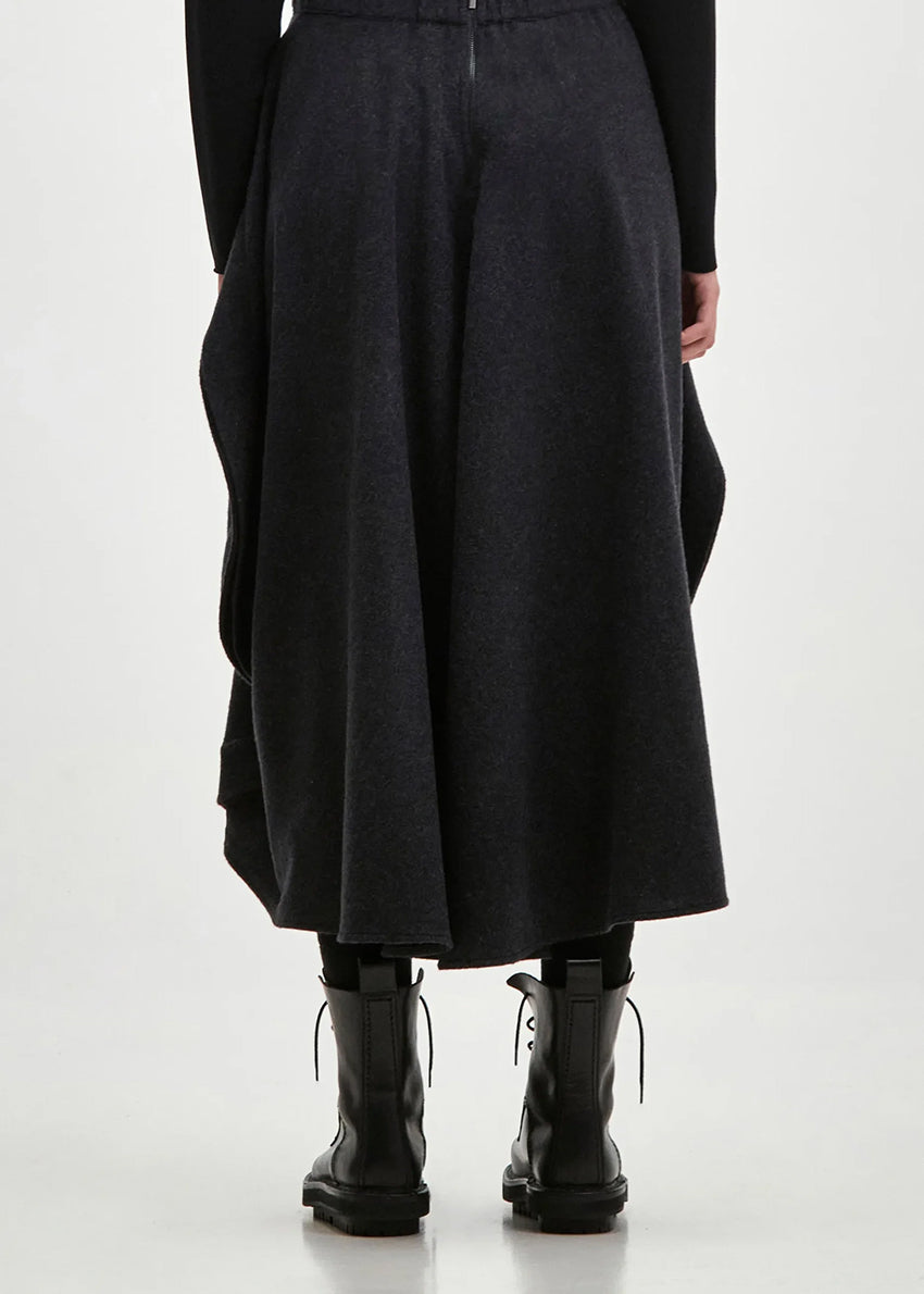 Asymmetrical skirt with a decorative diagonal ruffle made of soft blended wool flannel. ONDA features an elastic waistband and a zipper closure on the back side.