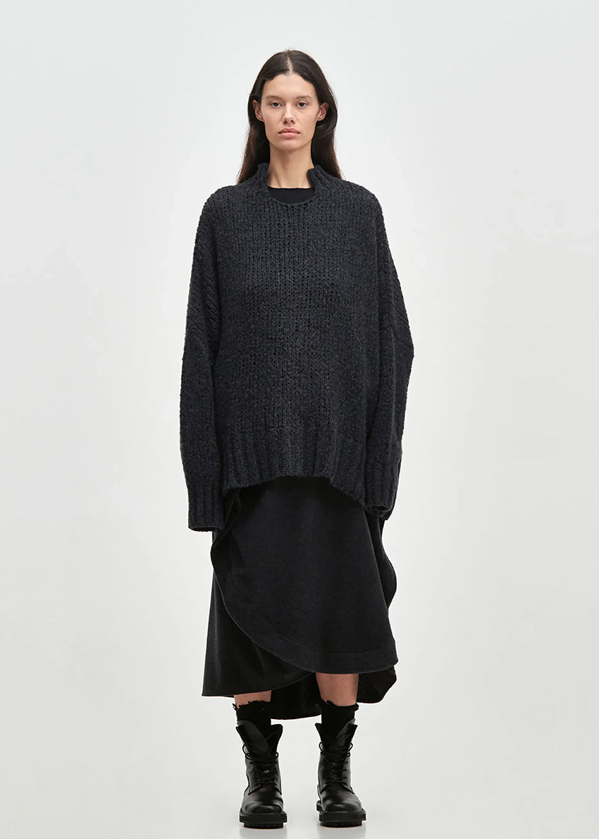 Asymmetrical skirt with a decorative diagonal ruffle made of soft blended wool flannel. ONDA features an elastic waistband and a zipper closure on the back side.