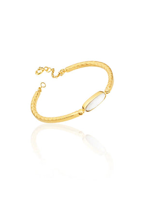 Gold bracelet with a white stone on a white background
