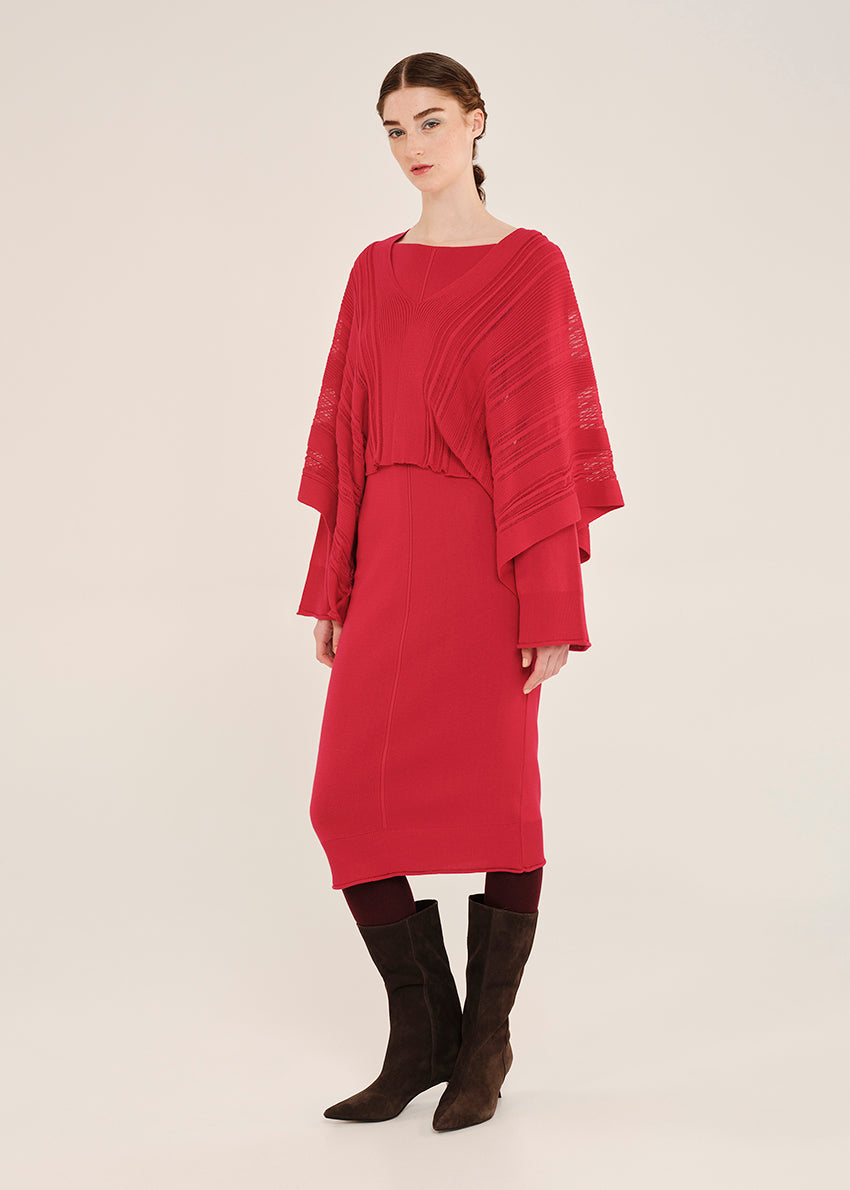 Woman wearing a red dress with a matching cardigan on a white background