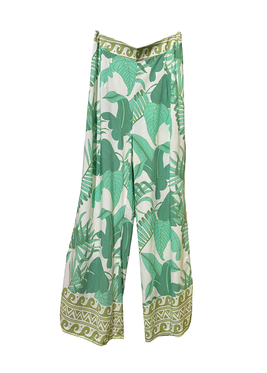 A pair of flared rayon pants with a green leaf pattern and decorative trim at the waist.