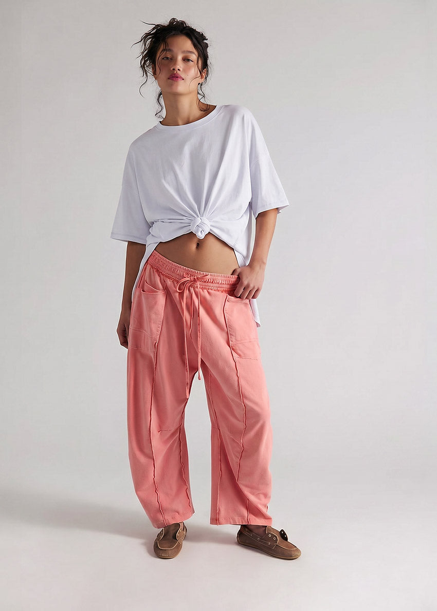 Person wearing a white t-shirt and pink pants on a plain background