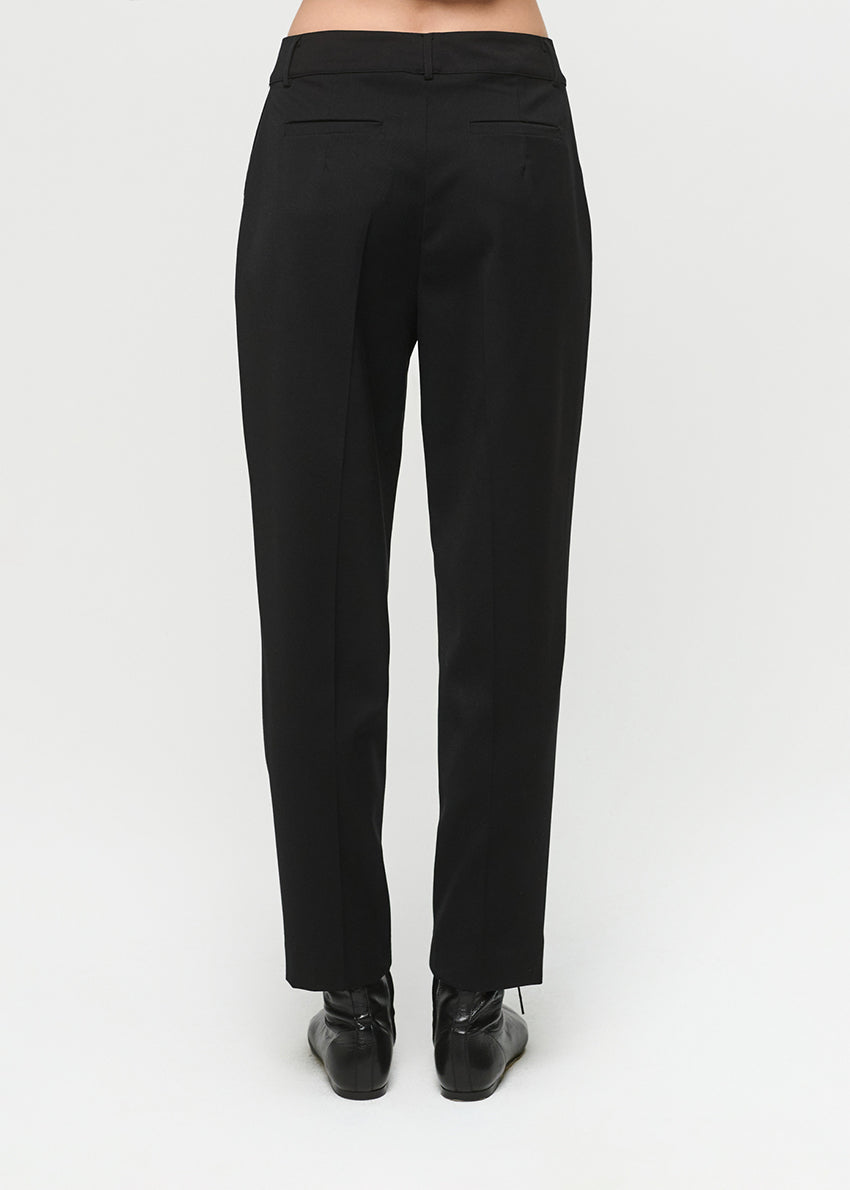 Black pants worn by a person on a white background