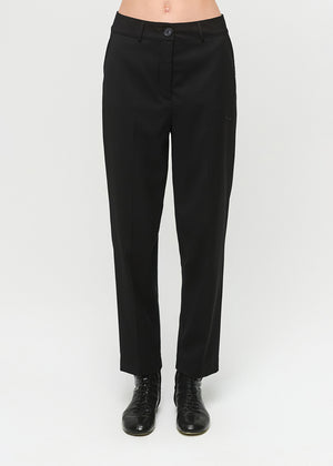 Black pants worn by a person on a white background