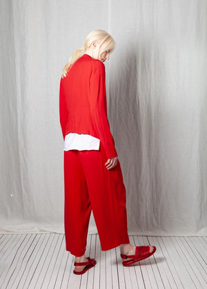 Person wearing a red outfit with a white shirt against a plain background