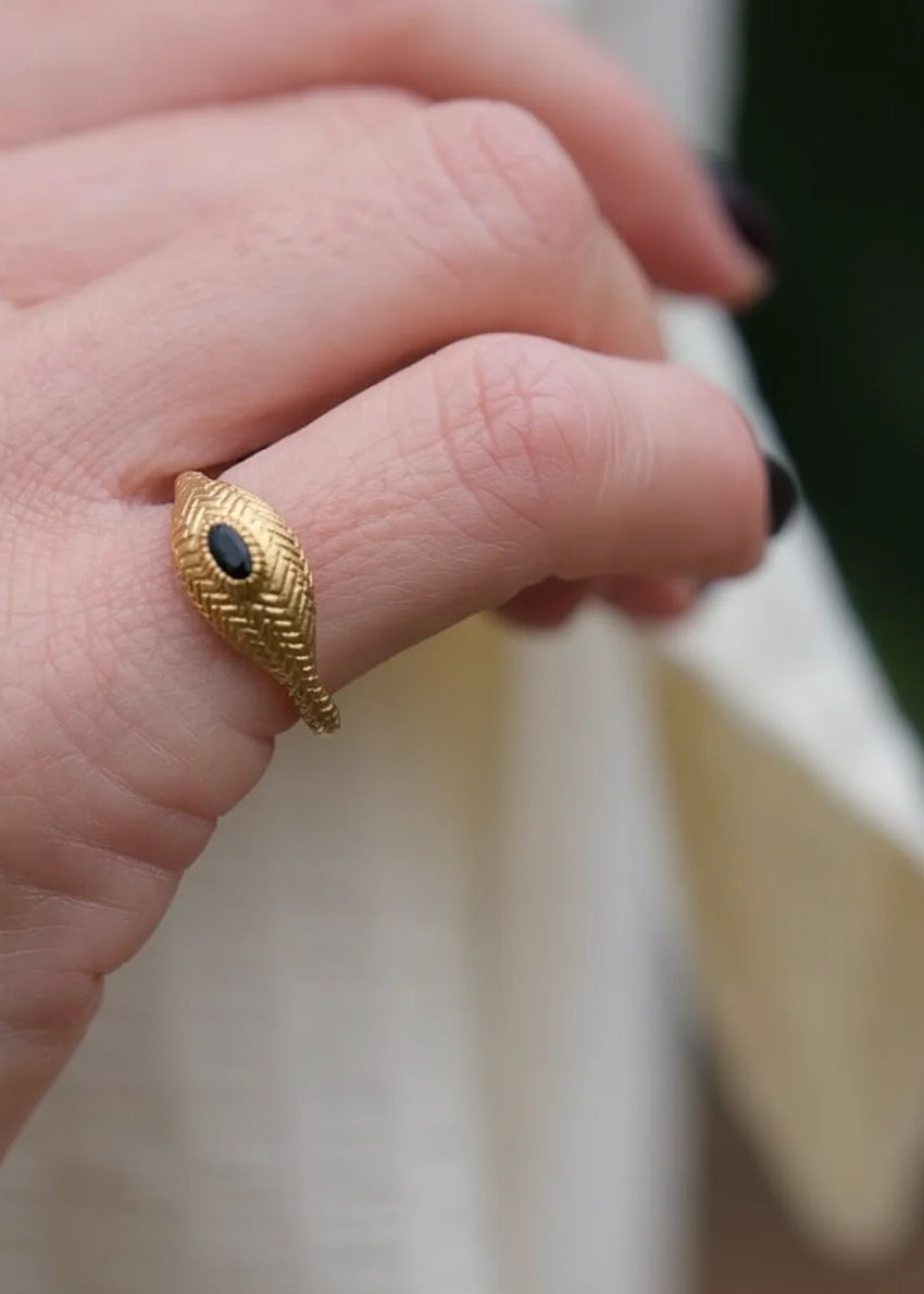 Gold ring with a black gemstone on a white background