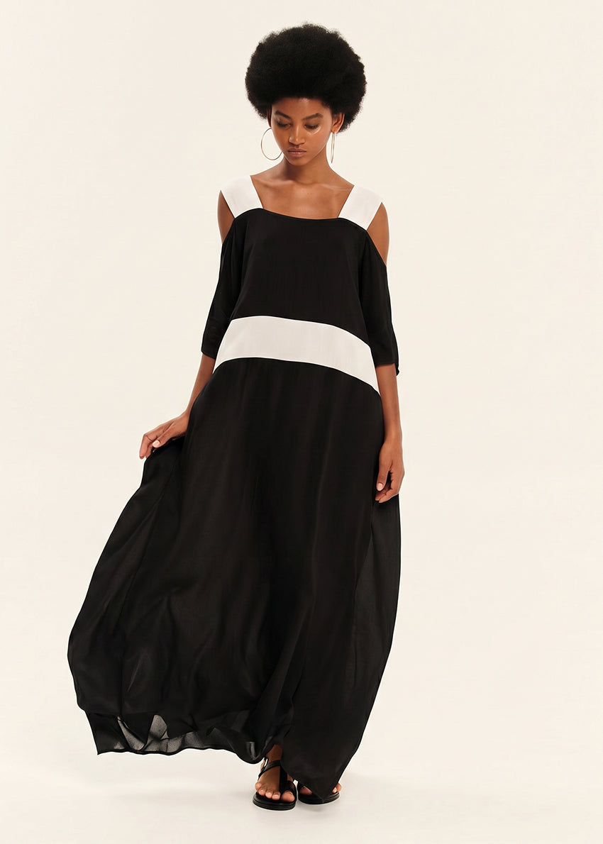 Woman wearing a black and white dress on a plain background