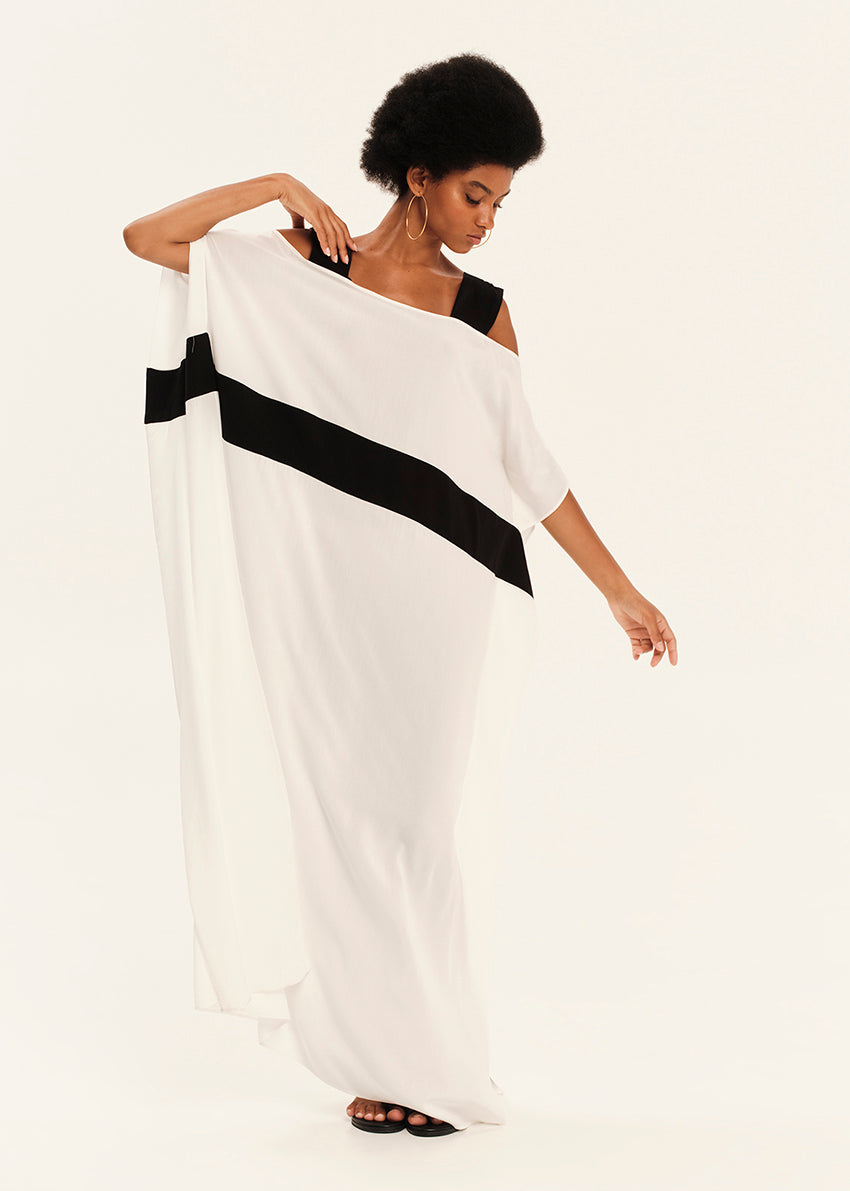 Woman wearing a white dress with black stripes on a plain background
