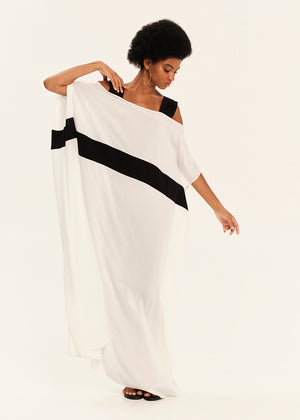 Woman wearing a white dress with black stripes on a plain background