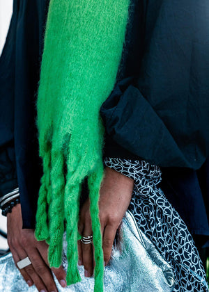 Envelop yourself in a cocoon of comfort with this exquisite green scarf. Its luxuriously soft texture provides a comforting touch. Enhancing the design, the scarf features medium-sized fringes create a subtle movement