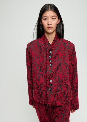 Model wearing a red and black patterned outfit on a plain background