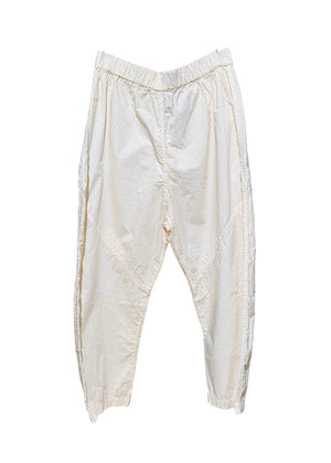 Cropped, drop-crotch unisex trousers, made from cotton poplin, in relaxed cut. These pants have an elastic waistband and diagonal seams just above the knee.
