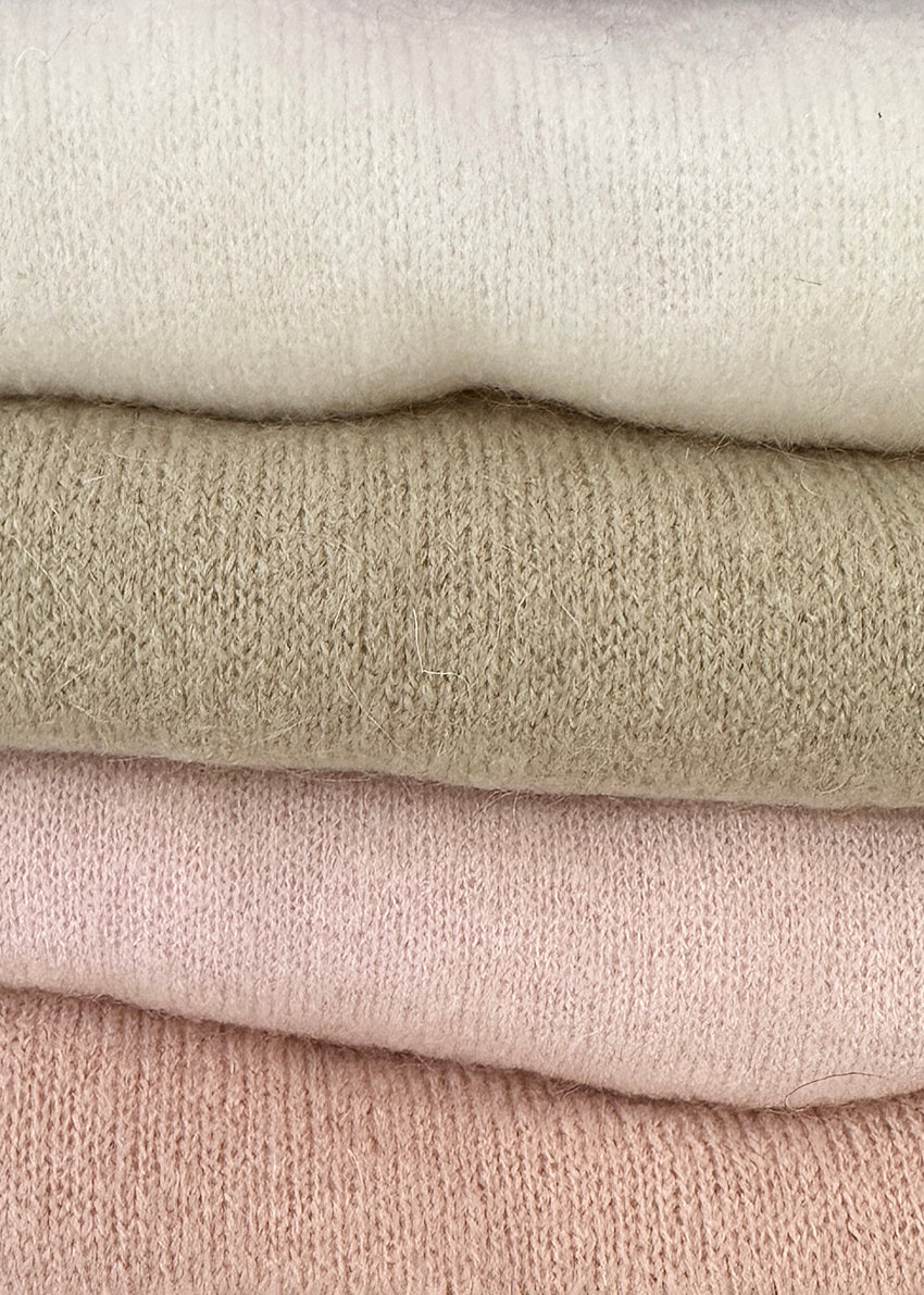 Nude, loose-fitting, long-sleeved sweater with a deep V neckline.