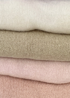 Nude, loose-fitting, long-sleeved sweater with a deep V neckline.