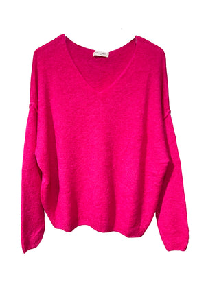 A deep pink, loose-fitting, long-sleeved sweater with a deep V neckline.