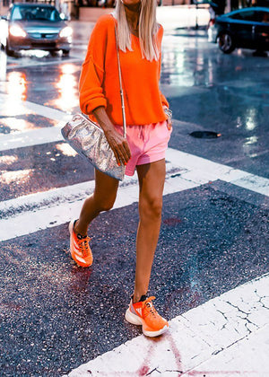 A orange, loose-fitting, long-sleeved sweater with a deep V neckline.
