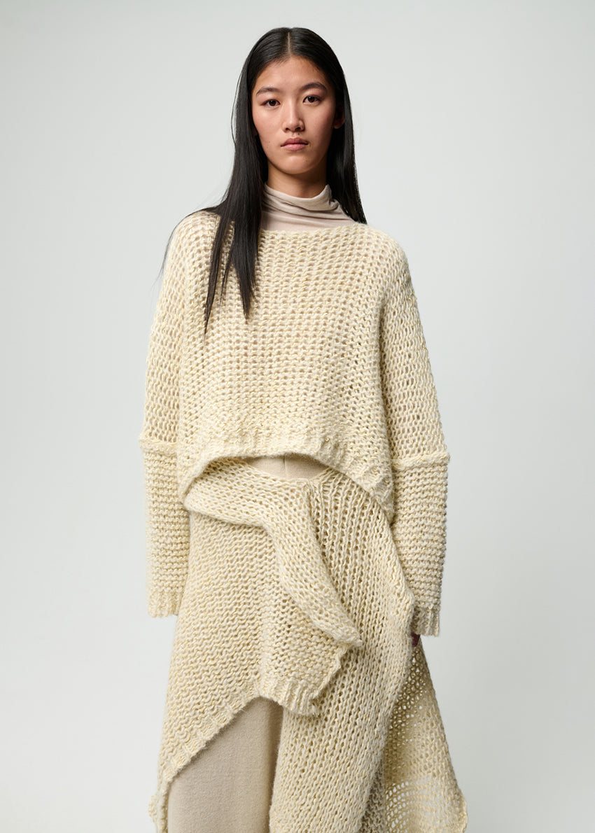 Woman wearing a beige knitted outfit on a plain background