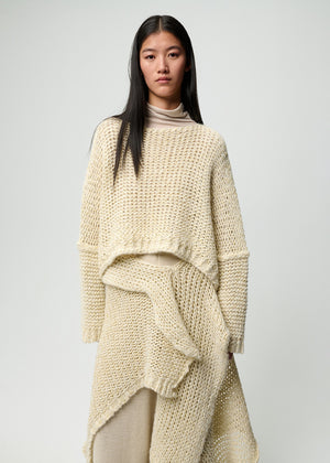 Woman wearing a beige knitted outfit on a plain background