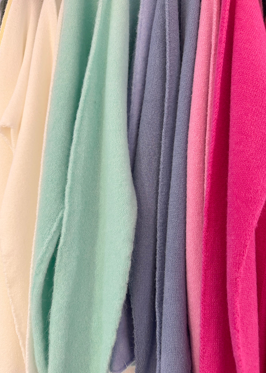 Stack of colorful fabrics in various shades.
