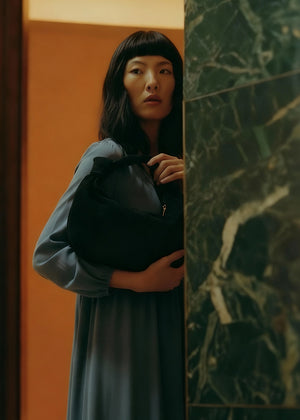 This is a stylish and contemporary hobo bag crafted from soft suede leather . Its slouchy, relaxed silhouette makes it an effortless choice for casual outings, while the luxurious suede adds a touch of sophistication. The bag features a single, wide handle with a chic knot detail, allowing it to sit comfortably on your shoulder.