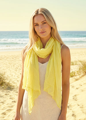 Woman wearing a yellow scarf on a beach