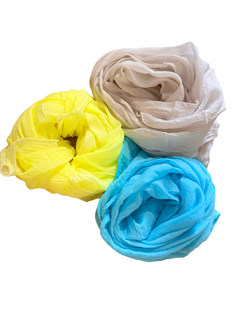Three scarves in yellow, wheat, and blue on a white background
