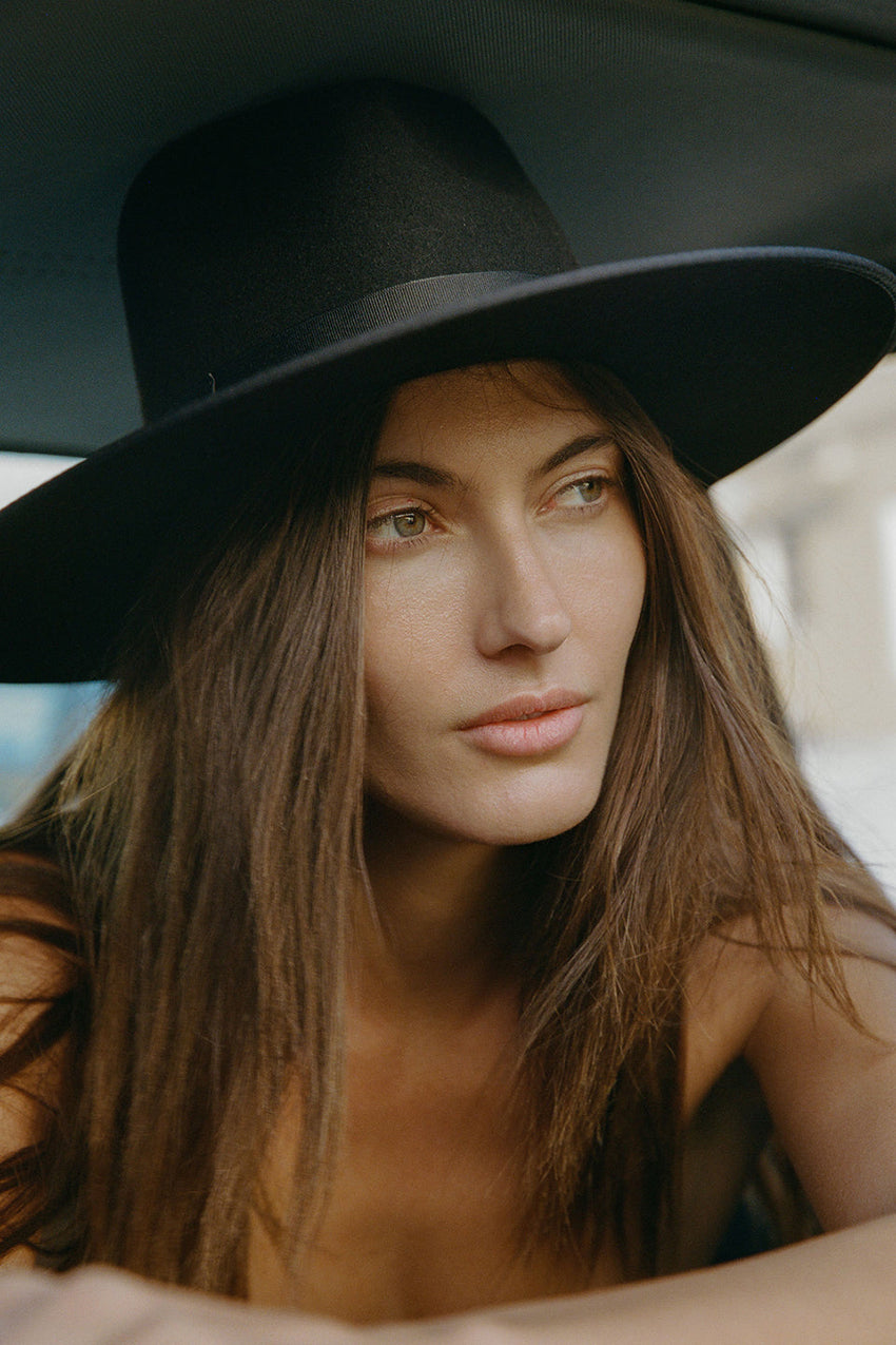 Woman wearing a black hat with a blurred background
