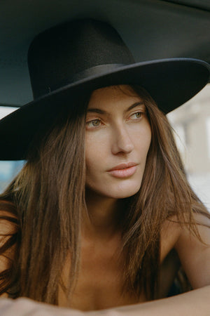 Woman wearing a black hat with a blurred background