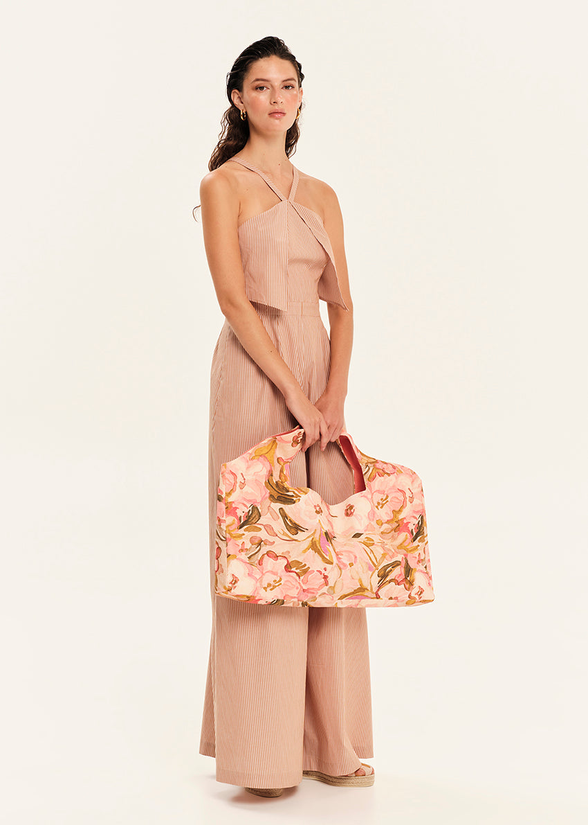 Woman holding a floral handbag against a white background