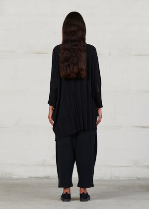 Asymmetrical unisex long-sleeved knitted blouse with grunge details, made of soft cotton yarn, featuring a a round neck.This long top-sweater can be worn from both sides (front-back)