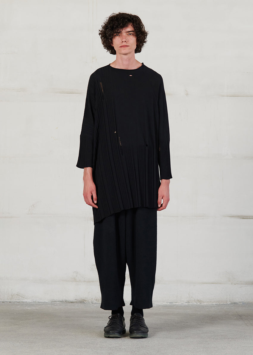 Asymmetrical unisex long-sleeved knitted blouse with grunge details, made of soft cotton yarn, featuring a a round neck.This long top-sweater can be worn from both sides (front-back)