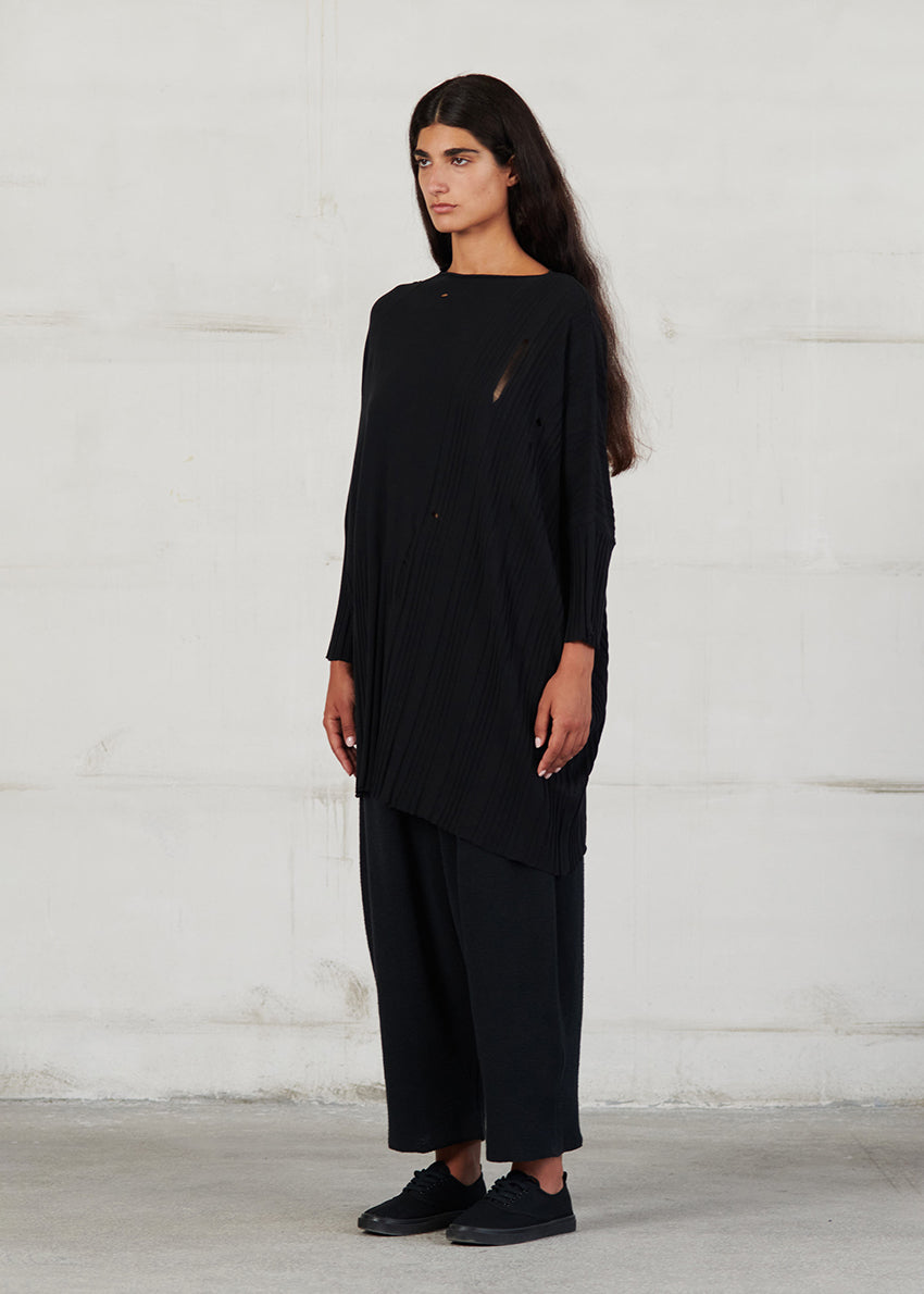 Asymmetrical unisex long-sleeved knitted blouse with grunge details, made of soft cotton yarn, featuring a a round neck.This long top-sweater can be worn from both sides (front-back)