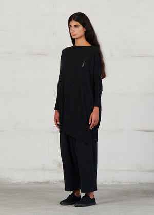 Asymmetrical unisex long-sleeved knitted blouse with grunge details, made of soft cotton yarn, featuring a a round neck.This long top-sweater can be worn from both sides (front-back)