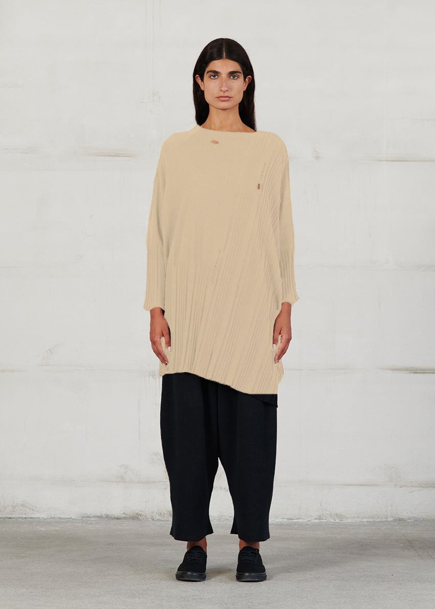 Asymmetrical unisex long-sleeved knitted blouse with grunge details, made of soft cotton yarn, featuring a a round neck.This long top-sweater can be worn from both sides (front-back)