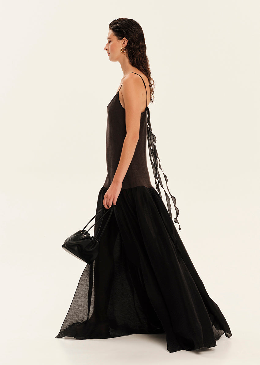 Woman wearing a black dress with sheer panels on a white background