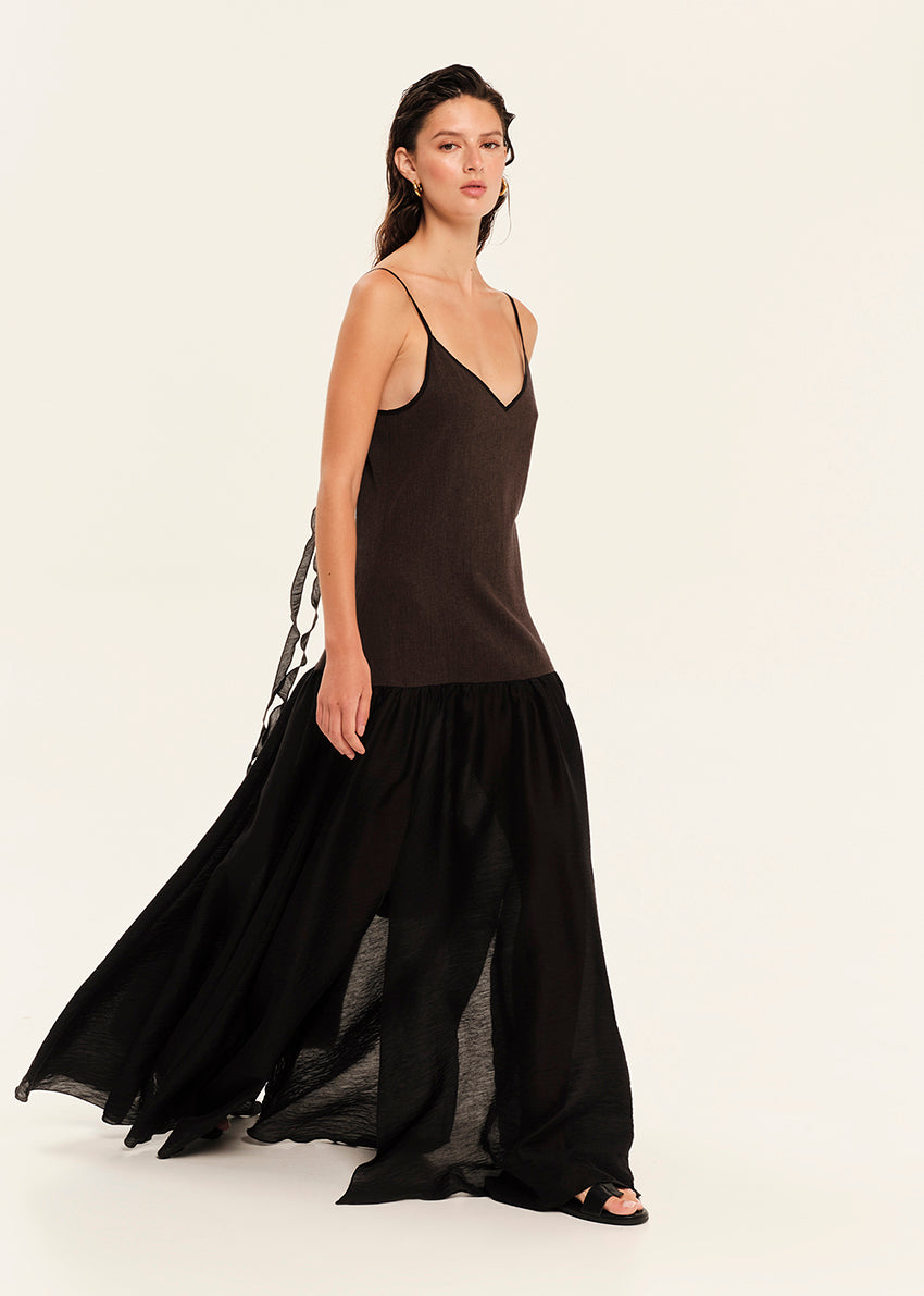 Woman wearing a black sleeveless maxi dress on a white background