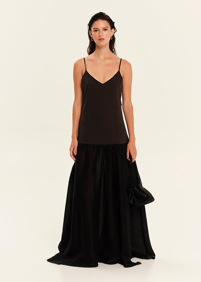 Woman wearing a black sleeveless maxi dress on a white background