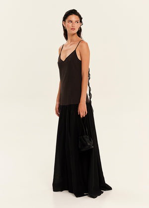 Woman wearing a black slip dress with a white background